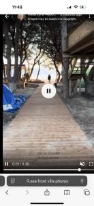 a screenshot of a video of a person walking down a path at Beach front villa 1 in Vlorë