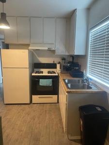 a kitchen with white cabinets and a stove and a sink at Pasadena single house in Pasadena +4 photos