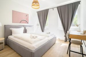 a bedroom with a bed with white sheets and a desk at 3-Zimmer-Wohnung in Hamburg am Flughafen in Hamburg