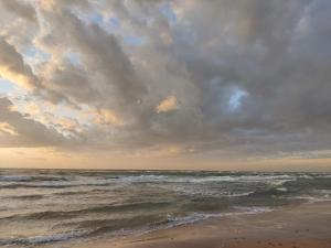 a cloudy sky over a beach with the ocean at Luxury Retreat in Lonstrup Oasis-By Traum in Hjørring