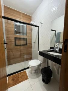 une salle de bain avec toilettes et douche en verre dans l'établissement Casa de praia em Cabo Frio, à Cabo Frio