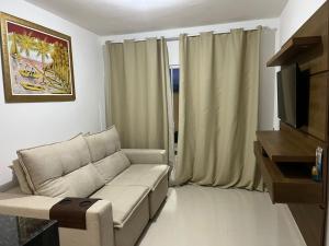 un salon avec un canapé et une télévision dans l'établissement Casa de praia em Cabo Frio, à Cabo Frio