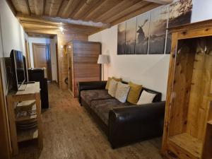 a living room with a couch and a television at Achthütte in Grossarl