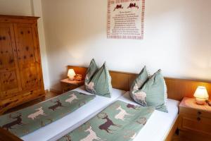 a bedroom with a bed with green sheets and pillows at Achthütte in Grossarl +3 photos