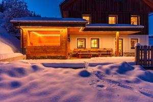 a log cabin in the snow with a pile of snow at Druckfeichter Hütte in Auberg