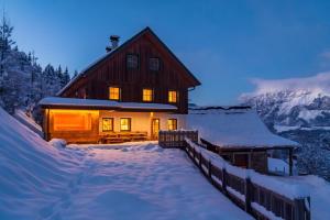 a log cabin in the snow at night at Druckfeichter Hütte in Auberg