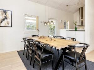 Un comedor con una gran mesa y sillas de madera. en Luxury Retreat Tranum Strand - By Traum Ferienwohnungen, en Brovst