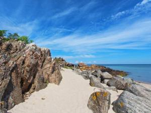 een strand met rotsen en zand en de oceaan bij 6 person holiday home in Allinge in Allinge +16 foto's
