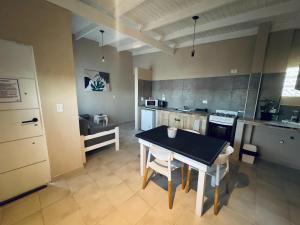 a kitchen with a table and a small kitchen with a stove at Apart Los Laureles Dpto 2 in Villa Regina +12 photos