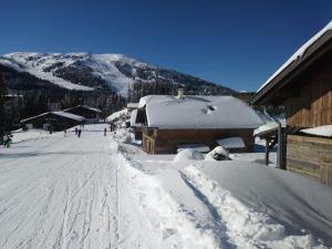 een skipiste met sneeuw op de grond en een gebouw bij Almchalet am Katschberg in Katschberghöhe