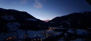 Blick auf eine Stadt in den Bergen in der Nacht in der Unterkunft Naturchalet INSToul in Luttach