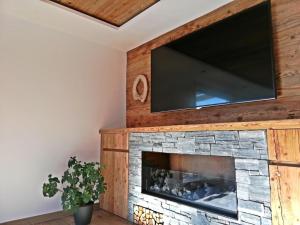ein Wohnzimmer mit einem Steinkamin und einem Flachbildfernseher in der Unterkunft Naturchalet INSToul in Luttach + 19 Fotos
