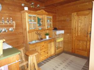 a log cabin kitchen with a sink and a stove at Neukam Hütte in Mühlbach am Hochkönig