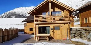 eine Blockhütte mit Veranda im Schnee in der Unterkunft Chalets Lagaun in Villetta