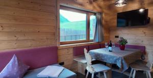 ein Esszimmer mit einem Tisch und einem Fenster in der Unterkunft Chalets Lagaun in Villetta + 12 Fotos