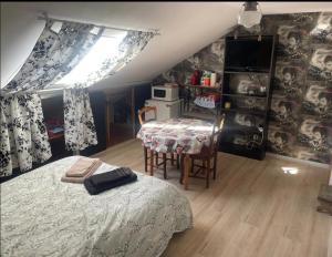 a bedroom with a bed and a table and a window at Voyage in Ouroux-sur-Saône