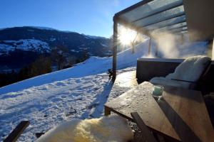 a snow covered porch with a table in the snow at Deluxe Suite Goldreh in Kaltenbach