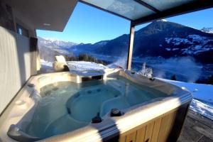 a jacuzzi tub with a view of a snowy mountain at Deluxe Suite Goldreh in Kaltenbach