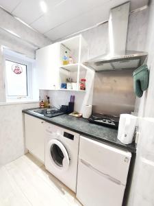 a white kitchen with a washer and dryer in it at The Wee Nest in Largs - One-Bedroom Ground Flat in Largs