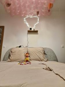 a heart balloon above a bed with a toy on it at Un spa privatif à 20 minutes de paris in Épinay-sur-Seine