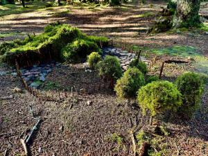 a garden with trees and rocks on the ground at Cozy Beach Cottage - By Traum Ferienwohnungen in Fjand Gårde