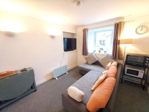 a living room with a couch and a tv at The Wee Nest in Largs - One-Bedroom Ground Flat in Largs