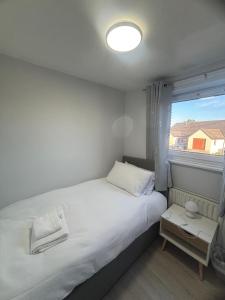 a small bedroom with a white bed and a window at Blencathra in Penrith