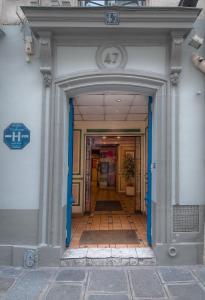 einen Eingang zu einem Gebäude mit blauer Tür in der Unterkunft Hotel Le Faubourg Opera in Paris