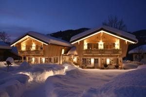a house covered in snow at night with lights at Chalet Rustika in Goldanger
