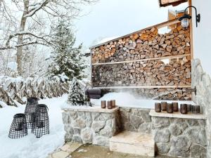 a pile of fire wood next to a stone wall at Chalet Rustika in Goldanger +26 photos