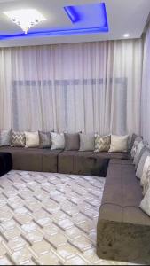 een woonkamer met een lange bank met gordijnen bij Modern Stay in Nouakchott