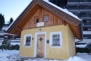 a small house with a wooden roof and a door at Stallerhütte in Bachwinkl