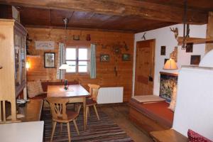 a living room with a table and chairs in a room at Stallerhütte in Bachwinkl