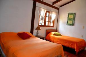 1 dormitorio con 2 camas y ventana en Posada Guasu, en Samaipata