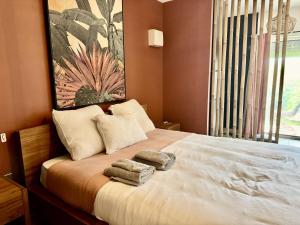 a bedroom with a bed with towels on it at Village Soleil in Îlet à Boissard