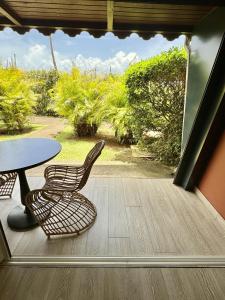 a patio with a table and two chairs and a table at Village Soleil in Îlet à Boissard