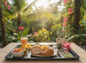 a tray with breakfast foods and drinks on a table at Hotel El Colibri Rojo - Le Colibri Rouge in Cahuita