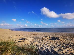 a sandy beach with the ocean in the background at Renovated Retreat near Beach - By Traum Ferienwohnungen in Blåvand