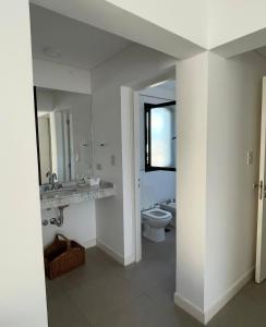 Un baño con inodoro, lavabo y espejo. en Spacious and comfortable apartment for 4 people, en El Durazno