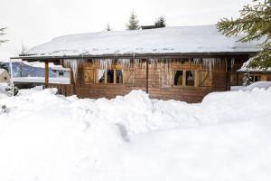 a house with a pile of snow in front of it at Alpen-Chalets Achensee in Häusern