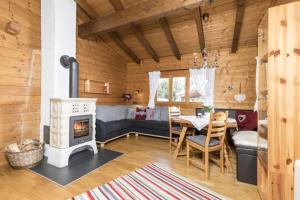 a living room with a couch and a stove at Alpen-Chalets Achensee in Häusern +9 photos