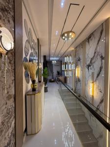 Un pasillo de un hotel con un vestíbulo con paredes de mármol. en ZELE homes, en Aja