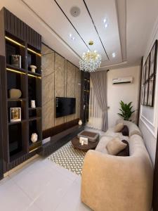 Una sala de estar con un sofá y un televisor. en ZELE homes, en Aja
