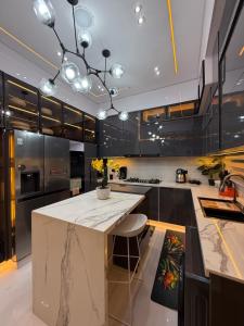 Una cocina con gabinetes negros y una encimera blanca. en ZELE homes, en Aja