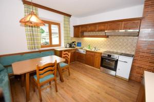 a kitchen with a wooden table and a wooden floor at Appartement Aschau in Aschau