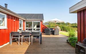 a patio with a table and chairs and an umbrella at Nice Home In Tarm With Sauna in Højsand +19 photos