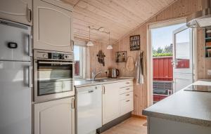 a kitchen with white appliances and a large window at Nice Home In Tarm With Sauna in Højsand
