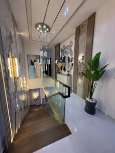 un pasillo con una escalera de cristal y una planta en maceta en ZELE homes, en Aja