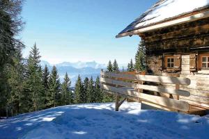 a bench sitting in the snow next to a cabin at Alpine-Lodges Lisa in Hintersauerwald