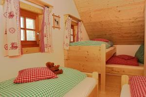 a bedroom with two bunk beds and a teddy bear at Alpine-Lodges Lisa in Hintersauerwald +10 photos